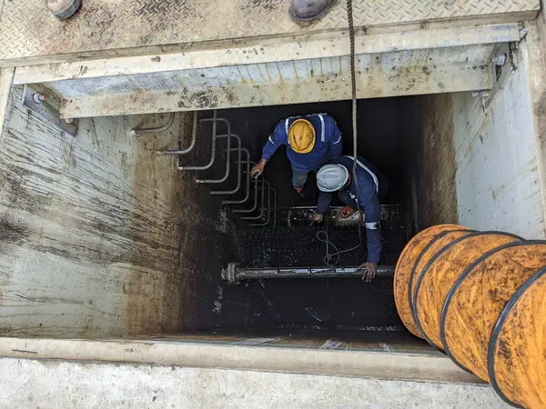 İki işçi bir tankı inceliyor.