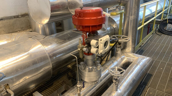 Крупный план промышленной системы клапанов и трубопроводов на заводе.