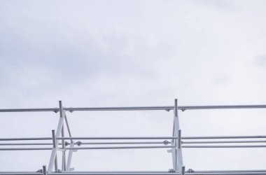 Bulutlu bir gökyüzüne karşı metal inşaat iskeletine bakan alçak açılı bir çekim..