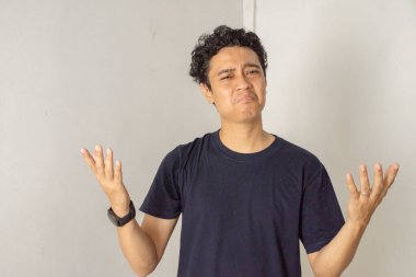 Kafası karışmış bir yüz ifadesi olan, sorgulama jesti yapan bir adam. Şüpheli ve kararsız görünüyor, sanki bir şeyi anlamakta zorlanıyor gibi..