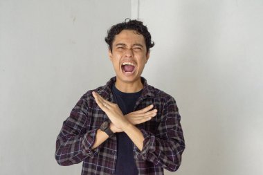 Hüsrana uğramış bir adam kollarını kavuşturup bağırıyor, olumsuz, reddeden bir hareket yapıyor.