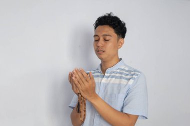 Dua eden genç bir adam, dinginliği ve kendini eve adamayı yansıtıyor..