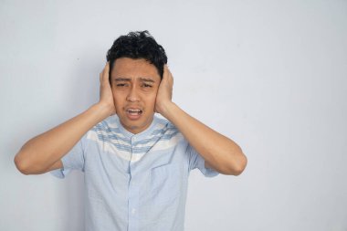 Sesi engellemek için kulaklarını tıkayan bir adam sıkıntılı görünüyor..