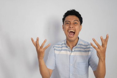 Bir adam güçlü bir öfke ve hayal kırıklığı ifadesi sergiler..