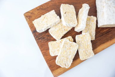 Raw Tempeh veya Tempe. Ahşap Arkaplanda Tempeh Dilimleri ve beyaz izole edilmiş. Metin için Boşluğu Kopyala