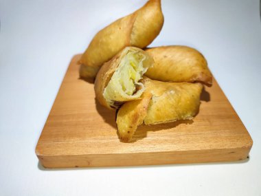 Fried banana wrap indonesian traditional food. The taste is sweet, crunchy outside and soft inside. top view of Pisang molen, Indonesian traditional food made from banana wrap with sheet of pastry dough and then fried. Isolated with white background