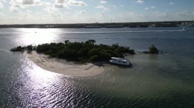 This 4K aerial drone footage offers a unique and visually stunning perspective of a boat anchored at a small tropical island. 