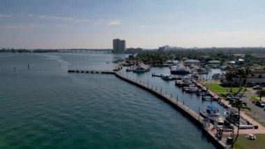 This 4K aerial drone footage offers a stunning view of a Florida pier, coastal beach, and ocean. The footage captures the natural beauty of the area, showcasing the crystal-clear water and the picturesque pier jutting out into the ocean.