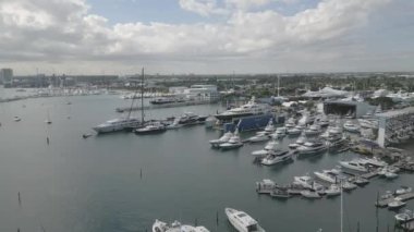 This 4K aerial drone footage is a true visual masterpiece, showcasing a collection of moored yachts and boats in the crystal clear turquoise waters. The footage is shot from high above the water, providing a bird's eye view of the vessels.