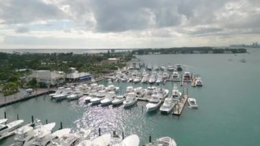 This 4K aerial drone footage is a true visual masterpiece, showcasing a collection of moored yachts and boats in the crystal clear turquoise waters. The footage is shot from high above the water, providing a bird's eye view of the vessels.