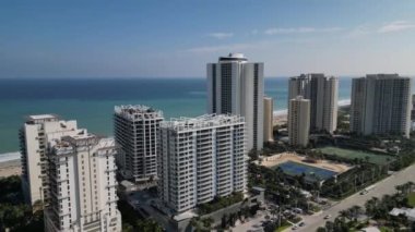 The footage provides a bird's-eye view of the building, showcasing its architecture, design, and location. The video highlights the building's location, the views of the ocean and the beach.
