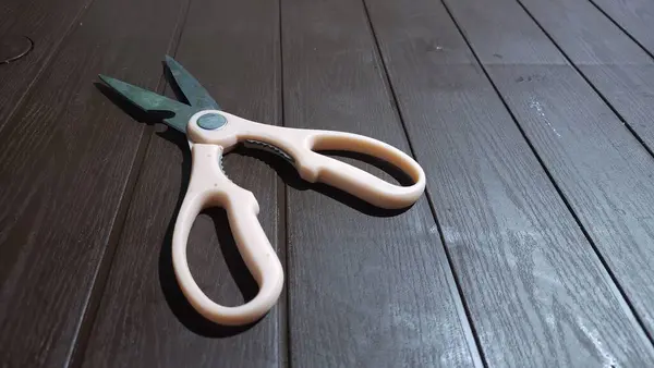 dirty scissors with pink handles on the table