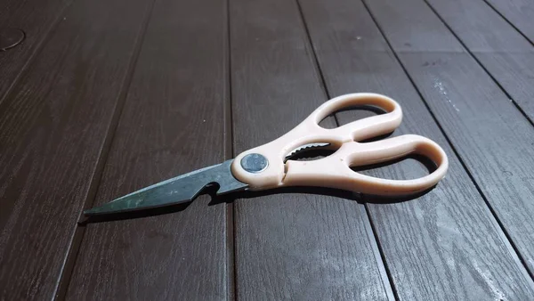dirty scissors with pink handles on the table