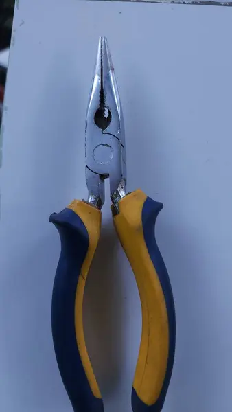 sharp pliers with yellow and green handles for carpentry tools