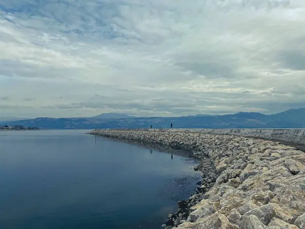 people walking on the pier on the lake