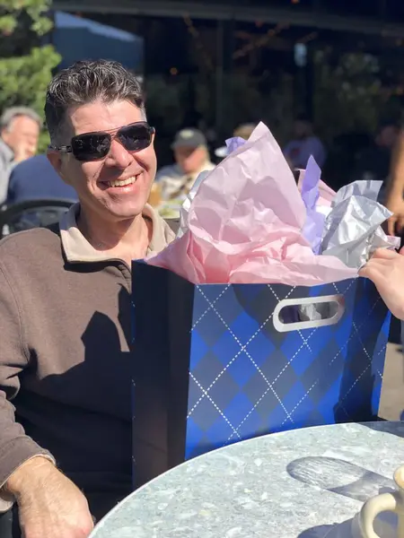 Bir baba sabırla Babalar Günü brunch 'ında hediyesini açmayı bekler..