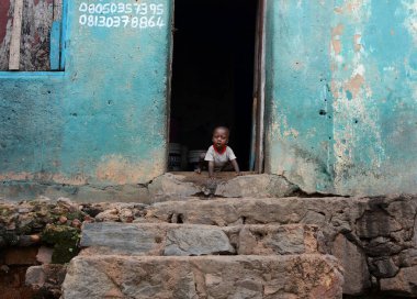 Little boy in front of a door at Ibadan