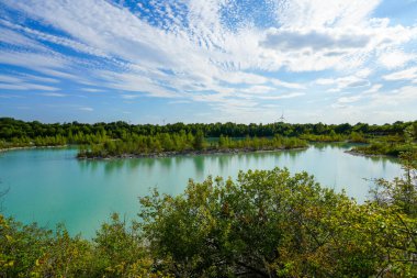 View of the Dyckerhoff lake in Beckum. Quarry west. Blue Lagoon. Landscape with a turquoise blue lake and the surrounding nature.