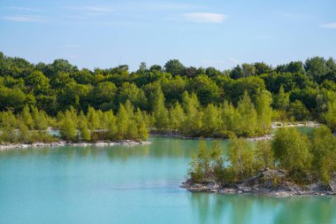 View of the Dyckerhoff lake in Beckum. Quarry west. Blue Lagoon. Landscape with a turquoise blue lake and the surrounding nature.