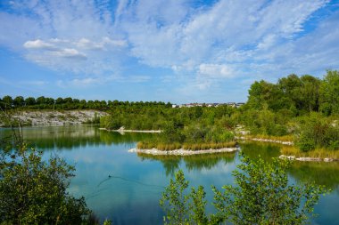 View of the Dyckerhoff lake in Beckum. Quarry west. Blue Lagoon. Landscape with a turquoise blue lake and the surrounding nature.