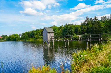 Kranicher Teich in the spa gardens of Hahnenklee. Idyllic landscape by the lake with an old Striegelhaus. Nature by the water with a Striegelanlage.