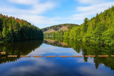 Oker reservoir near Altenau in the Harz Mountains. View from the Okertalsperre to the Oker See and the surrounding landscape. Idyllic nature by the water.