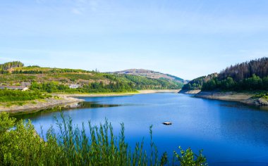 Oker reservoir near Altenau in the Harz Mountains. View from the Okertalsperre to the Oker See and the surrounding landscape. Idyllic nature by the water.