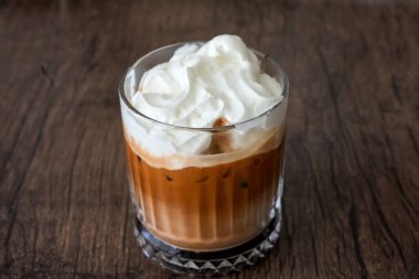 Krem şantili buzlu mocha. Kahverengi arka planda soğuk kahve içeceğiz..
