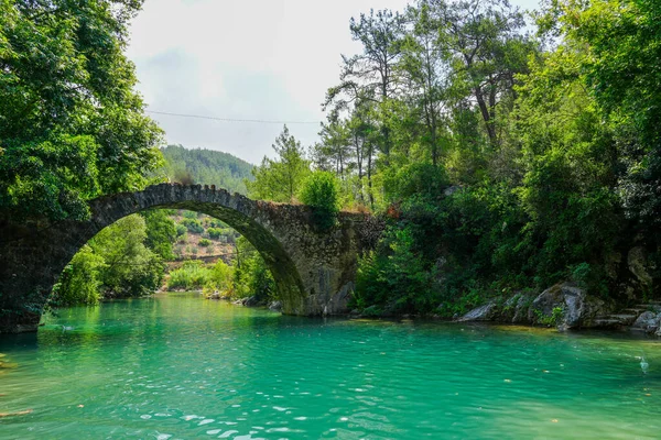 stock image Ancient roman bridge on Dim river in Turkey. Clear turquoise water and green nature.