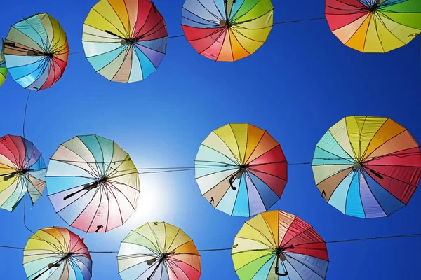 Colorful umbrellas for sun protection. Blue sky in the background. Rainbow colors.