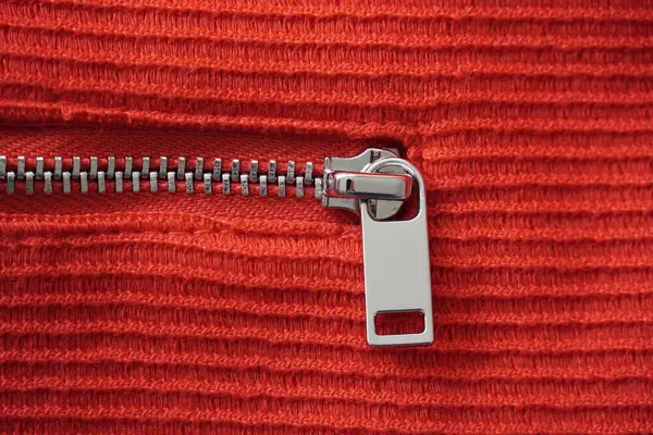 stock image Silver colored metal zipper on a red fabric.