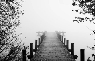 Sisteki Jetty. Göldeki mistik sisli manzara. Sonbaharda sabah sisi.