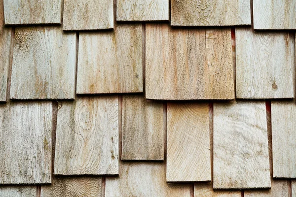 Wood paneling of a wall with wooden shingles. Background with wood texture