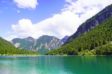 Tyrol, Avusturya 'daki Plansee' de manzara. Turkuaz renkli göl çevresi ve dağlarla çevrili..