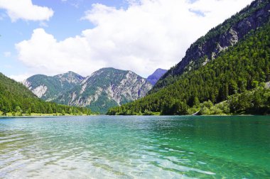 Tyrol, Avusturya 'daki Plansee' de manzara. Turkuaz renkli göl çevresi ve dağlarla çevrili..