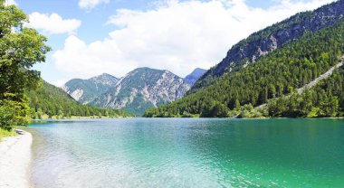 Tyrol, Avusturya 'daki Plansee' de manzara. Turkuaz renkli göl çevresi ve dağlarla çevrili..