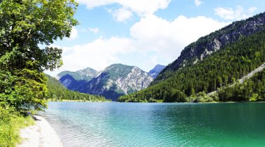 Tyrol, Avusturya 'daki Plansee' de manzara. Turkuaz renkli göl çevresi ve dağlarla çevrili..