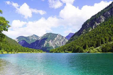 Tyrol, Avusturya 'daki Plansee' de manzara. Turkuaz renkli göl çevresi ve dağlarla çevrili..
