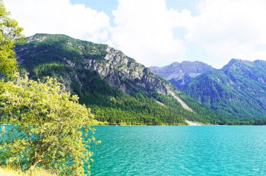 Tyrol, Avusturya 'daki Plansee' de manzara. Turkuaz renkli göl çevresi ve dağlarla çevrili..