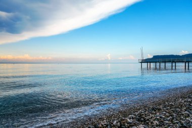 Kemer yakınlarında Akdeniz. Türkiye 'de manzara. Sahilde doğa arka planda bir iskeleyle.