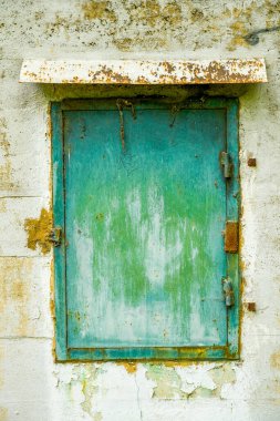 Terk edilmiş bir sığınağın eski yeşil metal penceresi..