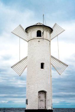 Baltık Denizi 'ndeki Swinoujscie' de Muehlenbake. Dört yel değirmeni bıçaklı yuvarlak taş kule. Limana girmek için bir navigasyon işareti.