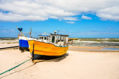 Polonya 'da Niechorze yakınlarında bir plaj. Beyaz kum ve balıkçı tekneleriyle Polonya Baltık Denizi 'nin doğal kıyıları. Deniz manzarası..