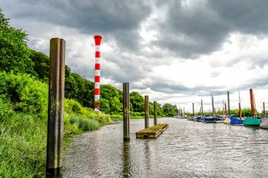 Hamburg yakınlarında kırmızı ve beyaz deniz feneri Muehlenberg. Muehlenberg marinasındaki Elbe 'deki tarihi deniz feneri..