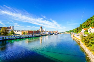 Passau şehrindeki nehir kıyısındaki bazı binaların ve çevrenin manzarası..