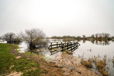 View of Lake Gartow in the municipality of Gartow in Lower Saxony. Winter landscape by the lake on a cloudy day. clipart