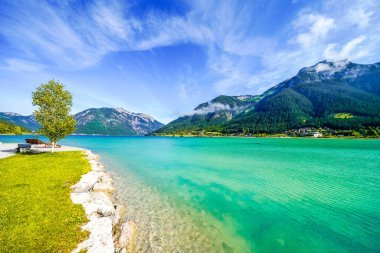 Tyrol 'daki Achensee Gölü manzarası. Turkuaz göldeki doğa ve arka planda bir dağ manzarası. Avusturya 'da Achental.
