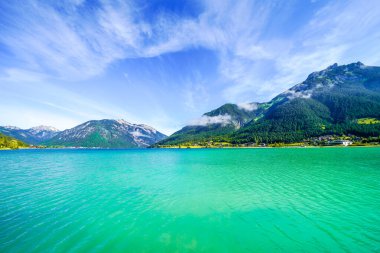 Tyrol 'daki Achensee Gölü manzarası. Turkuaz göldeki doğa ve arka planda bir dağ manzarası. Avusturya 'da Achental.