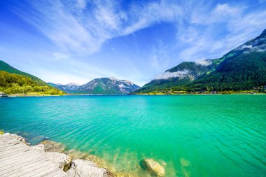 Tyrol 'daki Achensee Gölü manzarası. Turkuaz göldeki doğa ve arka planda bir dağ manzarası. Avusturya 'da Achental.