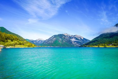 Tyrol 'daki Achensee Gölü manzarası. Turkuaz göldeki doğa ve arka planda bir dağ manzarası. Avusturya 'da Achental.